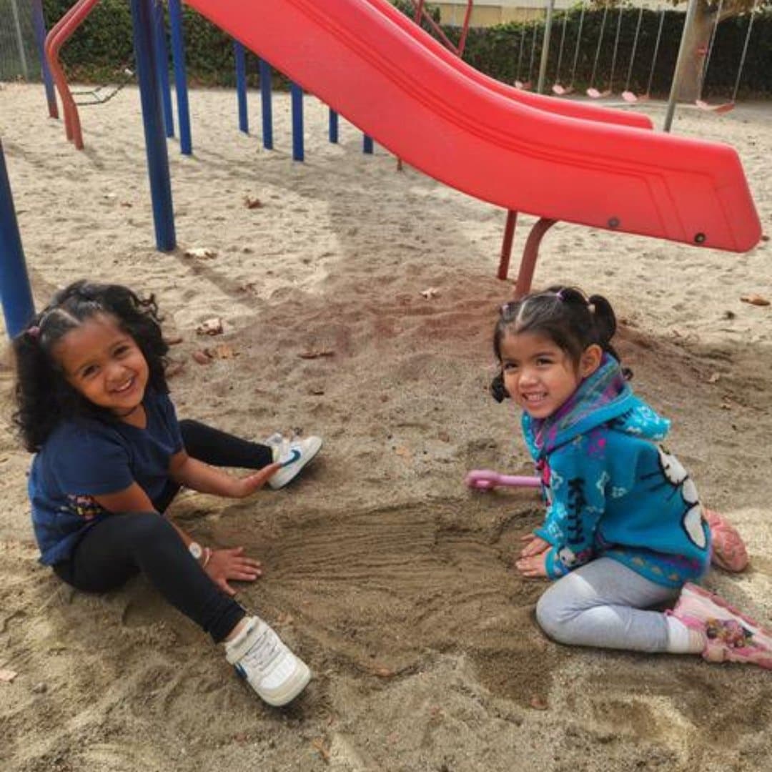 Students playing together in the playground sandbox