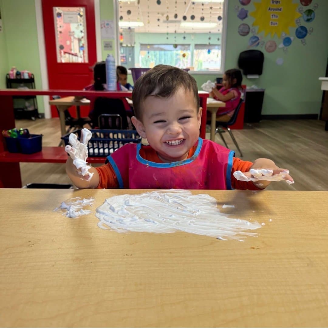 Student enjoying a shaving-cream sensory activity