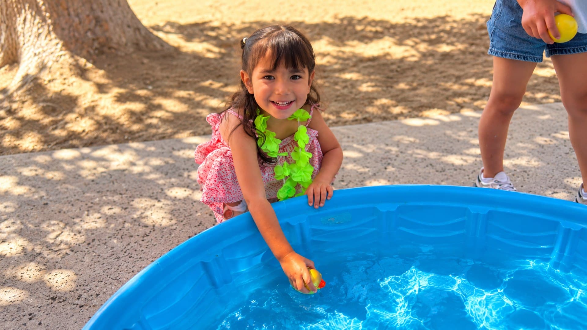 A joyful student playing outdoors at Little Explorers Academy