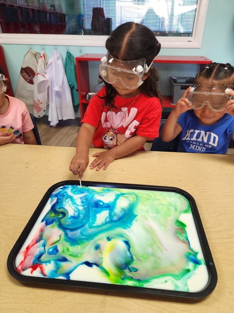 Preschoolers exploring a milk-marbling science experiment