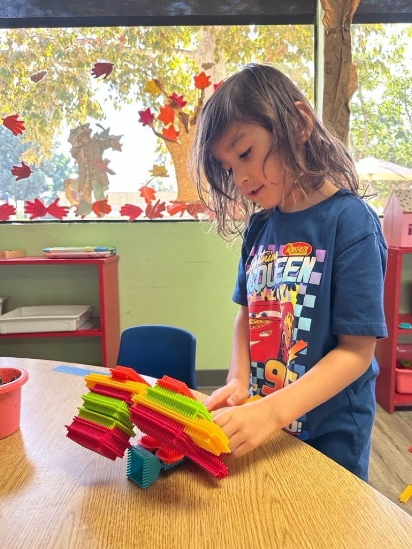 A student building with blocks in the classroom at Little Explorers Academy