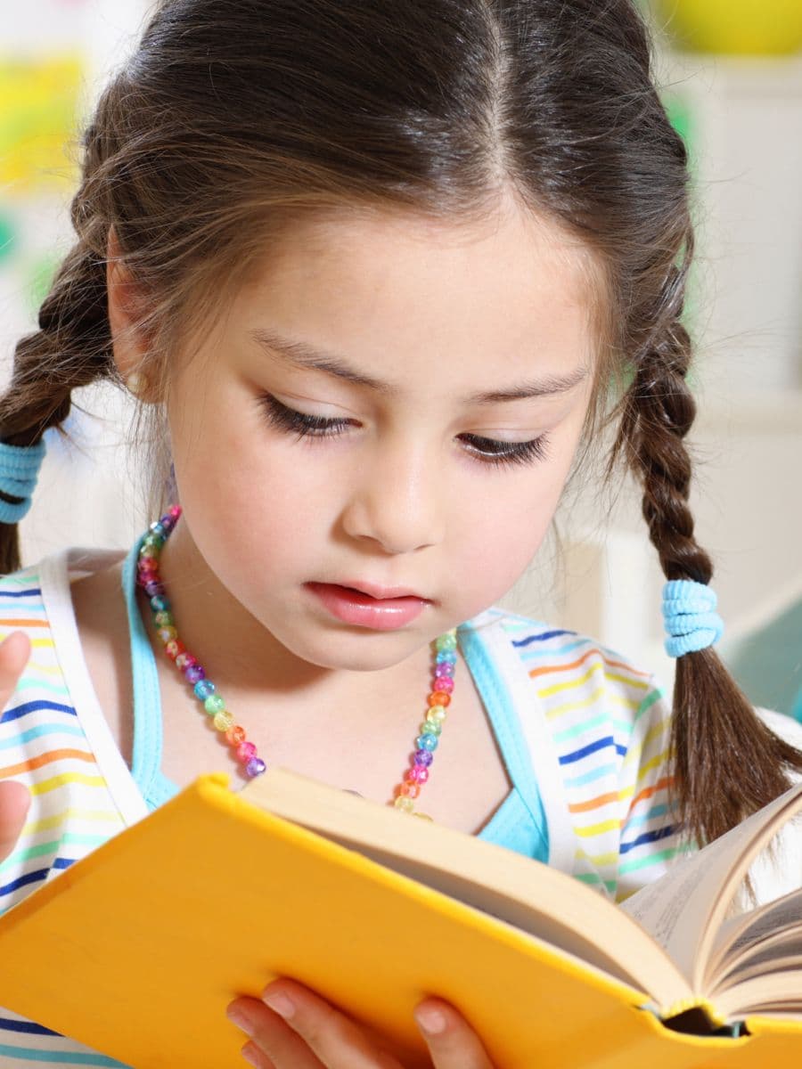 A student reading a book as part of bilingual storytime