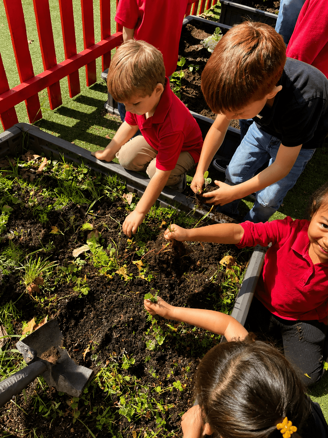 Campers tending the garden with a teacher