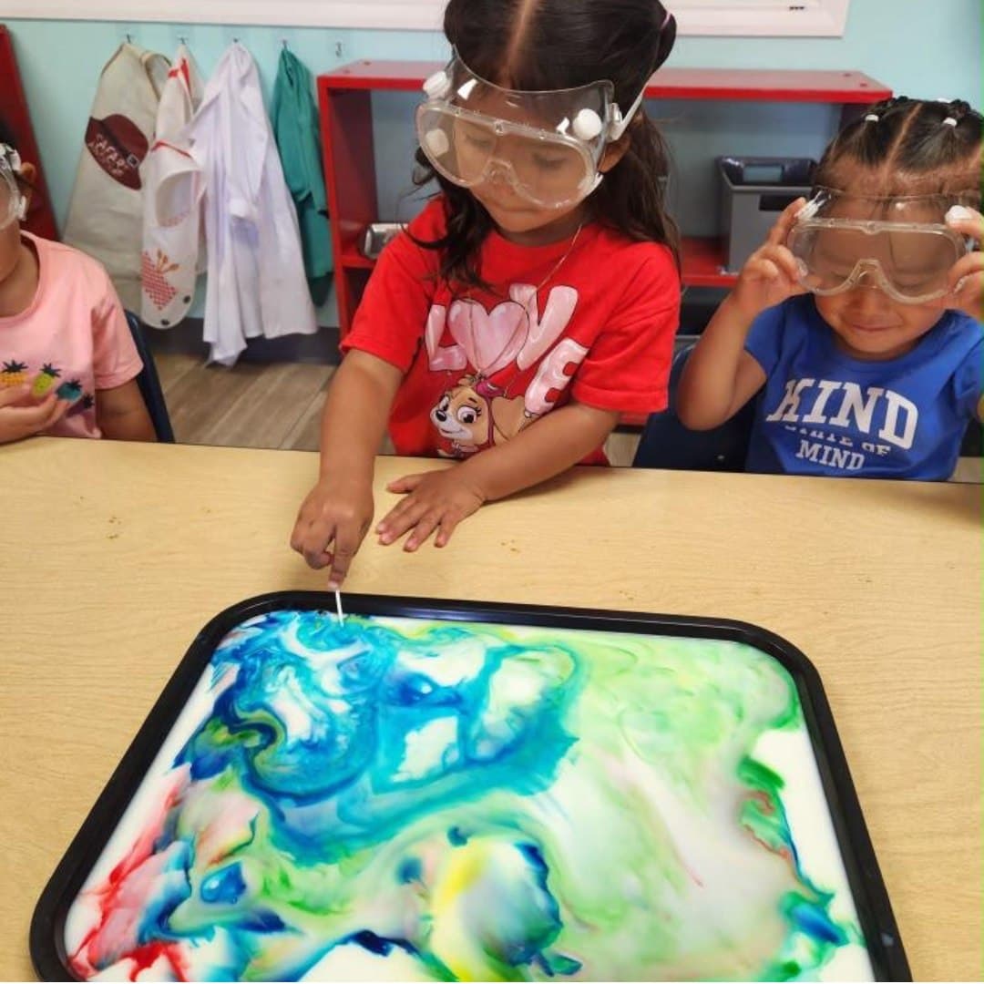 Preschoolers exploring a milk-marbling science experiment